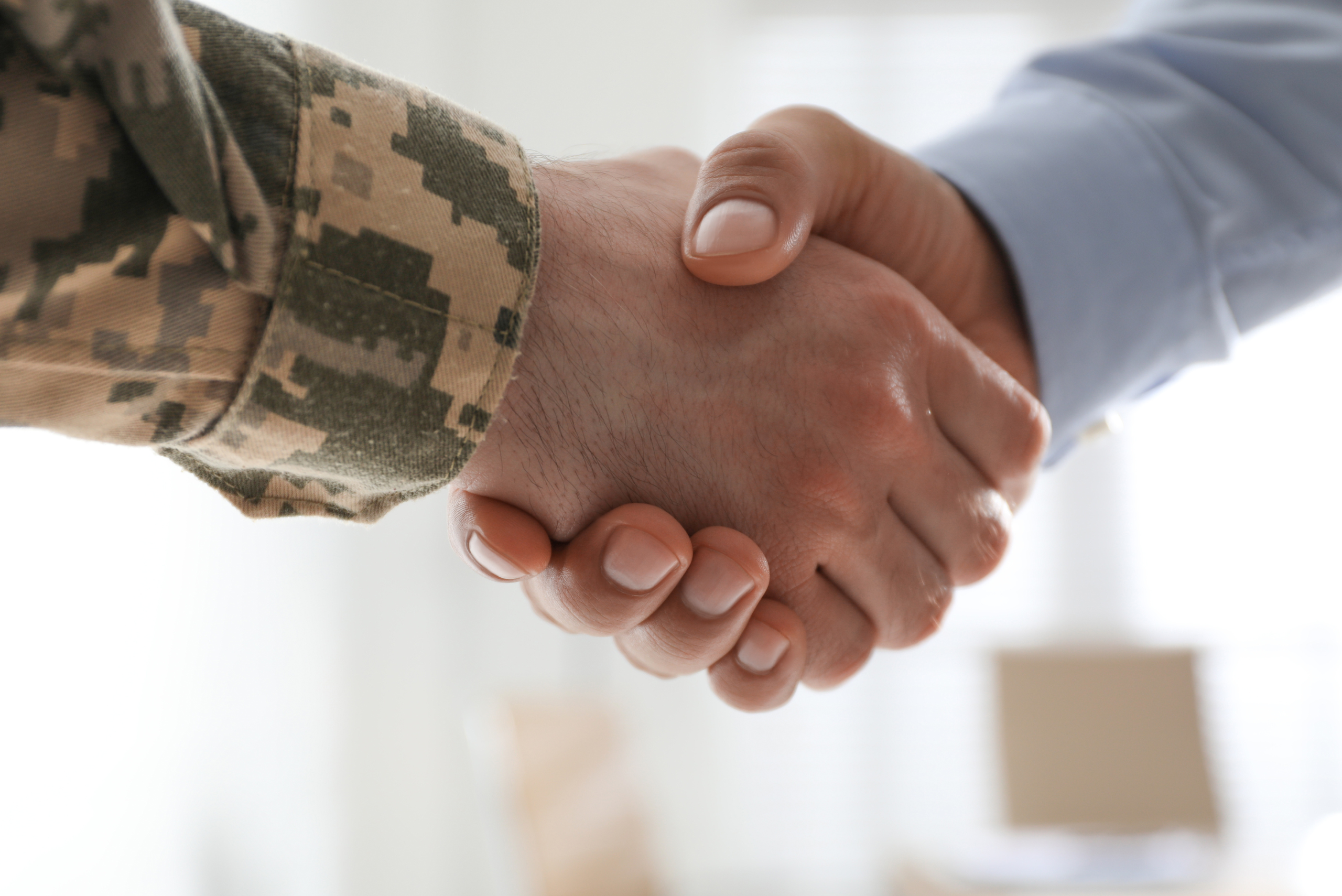 Soldier shaking business man's hand